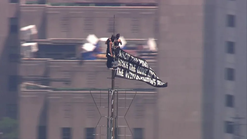 Imagini incredibile din New York: Două persoane mascate au urcat în vârful Empire State Building, cu un banner pentru pace: „Când puterea iubirii va învinge iubirea pentru putere, va fi pace în lume”